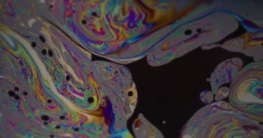 Yağ damlası. Mürekkep karışımı. Odaklanmamış yeşil mavi renk pembe mor yuvarlak doku soyut koyu siyah yaratıcı arka planda yüzüyor.