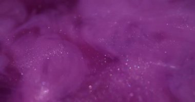 Işıldayan sıvı. Mürekkep dalgası. Pembe mor metalik toz sisi girdap suyu karıştırıyor. Parlak akış sıçrama yayılmış renk soyut arkaplan.