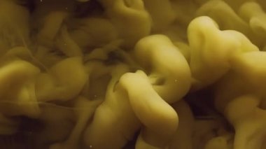 Sis dalgası. Duman bulutu. Odaklanmamış sarı renk buhar dokusu mürekkep sıvısı damlası soyut sanat arka planına yayılıyor..