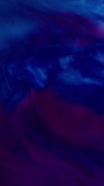 Dikey video. Boya sıvısı. Mor dalga. Mor pembe rengin tuhaf, pürüzsüz akışı. Enamel yağı çözünmüş sıvı ve farklı tonlarda boya..