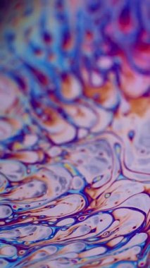 Dikey video. Soyut akış. Baloncuk sanatı. Odaklanmamış mor yeşil sıvı yağ eğrisi koyu siyah bulanık ışık arka planında akrilik kaygan.