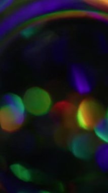 Dikey video. Bokeh ışığı. Bulanık renkli arka plan. Odaksız sızıntı. Sarı ışınlar. Gökkuşağı yanıp sönüyor..