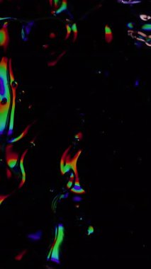 Dikey video. Köpüklü köpükler. Bulanık ıslak doku. Odaklanamayan sızıntı, çok renkli yeşil ışınlar gökkuşağı titreşimleri, koyu siyah soyut sanat ışığı arka planında yanıp sönen lens ışığı..