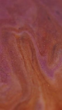 Dikey video. Mermer sıvısı. Bulanık boya dökülmüş. Odaklanmamış mor turuncu renk parıldayan desen emülsiyon mürekkep akışı dalgası karışım soyut sanat arka planı.