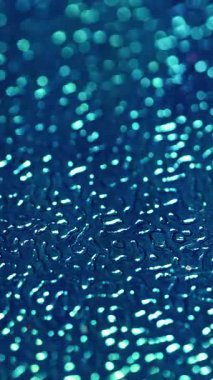 Dikey video. Odaklanmamış rahatlama. Kabartmalı plastik yüzey. Mavi taneli yapay deri, değişen ışıklandırmalı dalgalı plastik. Dekoratif parlak arkaplan.