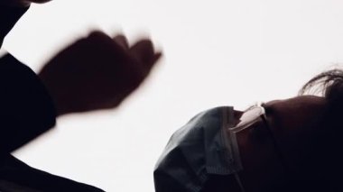 Dikey video. Salgın muhabbeti. Karantina devrede. Yüzü maskeli hasta bir adamın karanlık profilli silueti beyaz bir telefondan öksürüp mesaj atıyor..