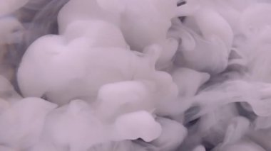 Mürekkep buharı. Atmosferik duman. Odaklanamayan beyaz renkli su akışı kimyasal serpinti soyut koyu siyah arka planda yayılıyor..