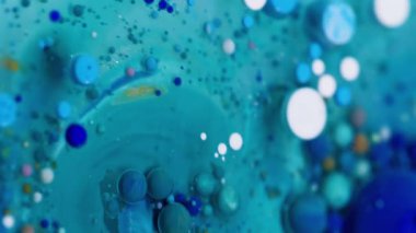 Dikey video. Boya akışı. Kabarcık emülsiyonu. Mistik mavi beyaz su karışımı çok renkli damlalar patlıyor. Dalga dökümü dokusu soyut arkaplan.