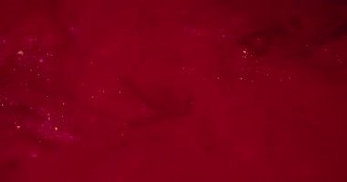 Işıl ışıl. Girdabı boya. Toz parçacıkları mürekkep emülsiyonu yayıyor. Kırmızı renk dokusu soyut bulanık scintilla girdap arkaplanı.