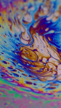 Dikey video. Psikedelik boya. Sabun köpükleri. Odaklanmamış mor yeşil sıvı boya gökkuşağı eğrisi akrilik kaygan koyu siyah bulanık ışık soyut sanat arka planı.