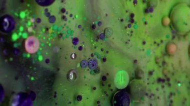 Dikey video. Kabarcık emülsiyonu. Köpük boyası. Yüzen çok renkli sanat sıvısı su dokusunu düşürür. Fantezi yeşil menekşe katmanlı soyut arka plan sıvısı.