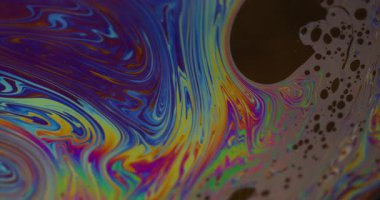 Mürekkep at. Benzin sanatı. Odaklanamayan mavi yeşil renkli ıslak kabarcıklar soyut koyu siyah arkaplan üzerinde yüzen sıvı.