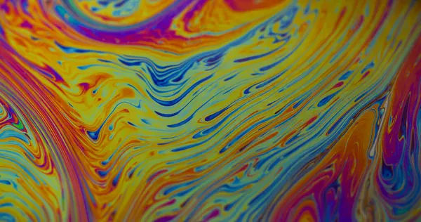 Yakıt dökülüyor. Yanardöner sanat. Bulanık sarı mavi mor renk akan kimyasal boya suyu soyut yaratıcı arka planda yüzer..