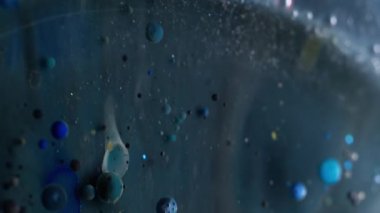 Dikey video. Emülsiyonu bırak. Yağ sıvısı. Renk pigmentleri olan karanlık mistik kozmik akışa karışıyor. Bulanık boya soyut su arkaplanı.