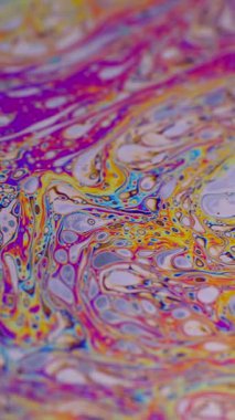 Dikey video. Boya karışımı. Neon sıvısı. Odaklanmamış mor yeşil sıvı yağ eğrisi koyu siyah bulanık ışık soyut sanat arka planında akrilik kaygan.