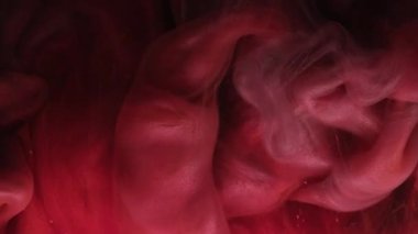 Parıldayan sis. Pembe sis. Suyun içindeki parıltılı boyanın dalgalı yansımaları. Peçe mürekkebi, parlak odaklı soyut arkaplanda pürüzsüz bir şekilde boya akışını kıvırır.