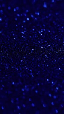 Dikey video. Bokeh ışıl ışıl. Renkli sim. İnce metalik tozla parıldayan ışıltılı festival yüzeyi. Gökkuşağının çözünürlüğü parlak toz üzerinde taşar..