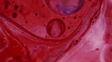 Yağ sıvısı. Odaklanamayan parlayan sıvı. Yanıp sönen kırmızı beyaz parlak renkli su bulanık bokeh ışıklı arka planda hareket ediyor..