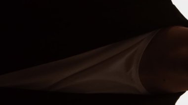 Dikey video. Depresif salgın. Karantina depresyonu. Yüzü maske takan, beyaz gözlüklü, üzgün bir iş adamının karanlık silueti..