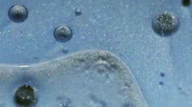 Işıl ışıl. Yağ sıvısı dokusu. Soyut sanat akrilik zemin üzerinde yüzen su yuvarlak parlak mürekkep damlasına odaklanmış mavi renk boyası.