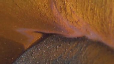 Shimmer döküldü. Lüks boya. Değerli sıvı toz altın sarısı turuncu akımlar sanat yüzey parçacıkları döküyor. Soyut gri karışım ıslak odaklanmış arkaplan.