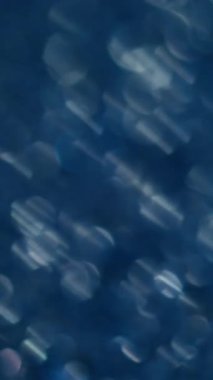 Dikey video. Bulanık parlaklık. Yanıp sönen parıltı. Renk değişimi ile dekoratif şenlik arka planı. Karmaşık ışınlar titreşiyor. Hassas atmosfer..