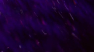 Parlak ışık. Odaklanamayan gökkuşağı yansıması. Mavi renk optik lensler bulanık koyu siyah soyut arka planda hareket eder.