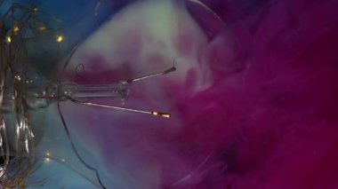 Dikey video. Çok renkli duman. Buhar akışı. Odaklanmamış mavi pembe boya akışı mermer su soyut arka plan yüzeyi. Kaotik sanat sıvısı fantezi fırıldak patlama.