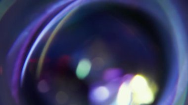 Yuvarlak yuvarlak. Bulanık ışık saçıyor. Soyut sanatın koyu siyah arkaplan üzerindeki sönük mor kırmızı yanıp sönen mercek dokusu.