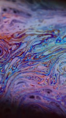 Dikey video. Mermer dokusu. Leke baloncuk yağı. Odaklanmamış mor yeşil sıvı boya eğrisi koyu siyah bulanık ışık soyut sanat arka planında akrilik kaygan.