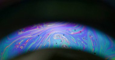 Sabun köpüğü. Neon kemeri. Renkli yuvarlak mercek, siyah arkaplanda karışık ışık akışı. Mor mavi gece soyut örtüyü çözdü.