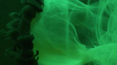 Dikey video. Sıvı dumanı. Yuvarlak doku. Odaklanmamış koyu yeşil neon rengi su boyası sıvısı soyut sanat arkaplan üzerinde şeffaf dalga.