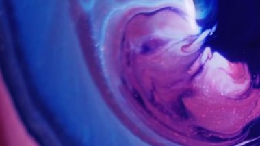 Akrilik pigment. Akışkan sanat. Soyut kimyasal arkaplanda yüzen suya mavi renkli diş minesi jölesi damlatıyorlar..