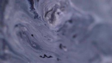 Damlayan mürekkep. Akış sanatı. Soyut akrilik yaratıcı arka planda akan suda odaksız mavi renkli parçacıklar sıvı boya.