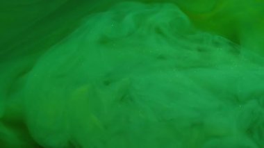 Mürekkep bulutu. Renk dumanı. Bulanık yeşil su dumanı kimyasal parıltı ışıl ışıl parlayan sisli doku sıvısı sanat soyutlaması üzerinde yüzüyor..