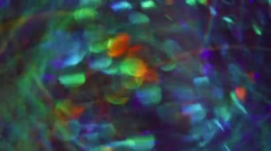 Bulanık karışık renkler. Parlak mercek parlıyor. Açık mavi turuncu kırmızı yeşil parçacıklar soyut arkaplanda bokeh etkisi ile parıldıyor.