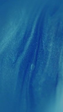 Dikey video. Parıldayan yağ damlaları. Bulanık boya sıvısı. Mavi beyaz çokrenkli ışıldayan sıvı su noktaları soyut bokeh ışık arkaplanı üzerinde hareket ediyor.