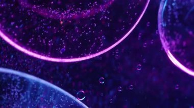 Odaklanmış damlacık. Yağ emülsiyonu. Mor mavi neon renkli akrilik desenli su soyut sanat ışığı arka planına yayılıyor..