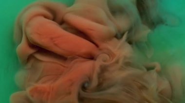 Mürekkebi karıştır. Akan boya. Odaklanmamış yeşil turuncu duman ruhani sis suyu nemli su soyut sanat arka planına kimyasal sıvı sıçratıyor.