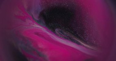 Akan sıvı. Parıldayan mürekkep. Odaklanmamış pembe neon rengi su parçacıkları soyut koyu siyah arkaplan üzerinde yüzen parlak doku..