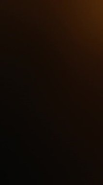 Dikey video. Odaklanamayan parıltı. Işık sızıntısı. Sarı turuncu parlak kıvılcım kıvılcımları koyu bulanık modern arka planda bokeh etkisi ile hareket ediyor.