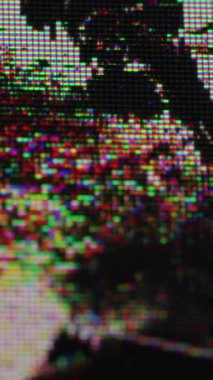 Dikey video. Hasarlı TV matrisi. Monitör kaplaması. Kırık LCD cam yüzeyinde renkli dijital piksel sesi. Odaklanamayan titreşimli hata arkaplanı.