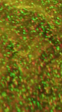 Dikey video. Pırıl pırıl bir üçgen. Kaleydoskop fişeği. Sarı mavi çok renkli noktalar ışıldayan parçacıklar Bokeh ışığı soyut arkaplan üzerinde hareket ediyor.