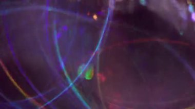 Çok renkli ışınlar. Bulanık parıltı. Sarı mavi turuncu mor iplikler soyut parlak kaleydoskop ışık arka planında hareket ediyor.