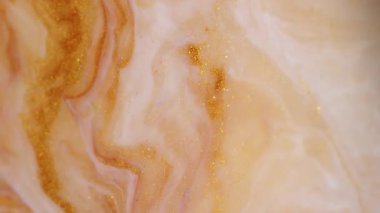 Parıltı karışımı. Boya damlası. Soyut arkaplana dökülen sarı altın sarısı beyaz parlak desenli jel emülsiyon dalgası.