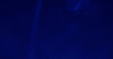 Sis dumanı. Su mürekkebi. Odaklanmamış mavi neon rengi duman buharı yuvarlak akrilik yaratıcı soyut sanat üzerine yayılıyor koyu siyah arka plan.