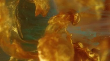 Dikey video. Parçacıklar boyar. Sıçrama küresi. Soyut sanat arka planında odaksız altın sarısı mavi parlak su dokusu.