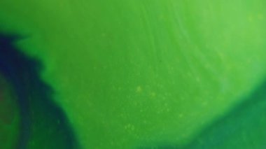 Mürekkep akışı. Islak doku. Odaklanamayan yeşil renkli sıvı akrilik sıvı dalgalanma parçacıkları soyut arkaplanda yüzüyor..