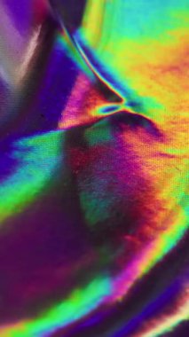 Dikey video. Folyo taştı. Renk karışımı. Metalik dalgalanma etkisi. Şenlikli dekoratif animasyon. Yakın çekim düzensiz doku, ani renk değişimi. Holografik alev sıvısı.