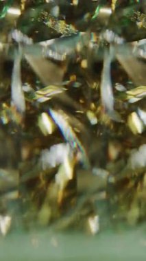 Dikey video. Neşeli bir parıltı. Bulanık Noel kurdeleleri. Işıldayan sarı altın rengi parlak parçacıklar soyut bokeh ışık arkaplanı üzerinde hareket ediyorlar.